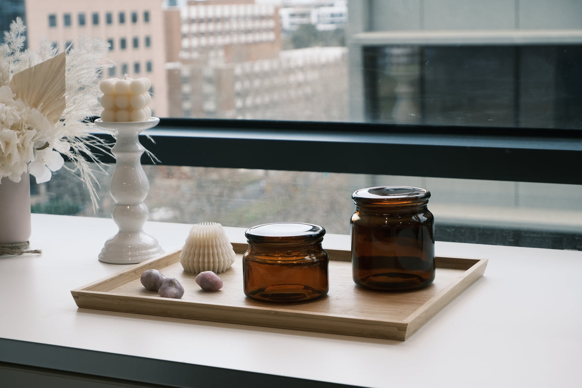 Two brown jars on a wooden tray