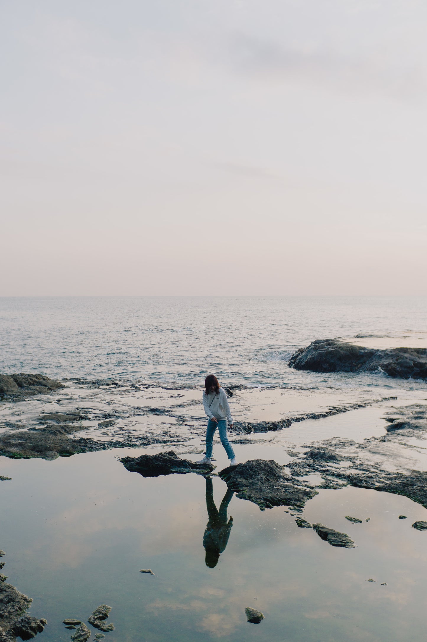 person-stands-on-ocean-shoreline